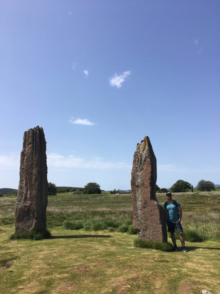 Jonathan Clarkin standing next to a standing stone at Machrie while visiting the Isle of Arran