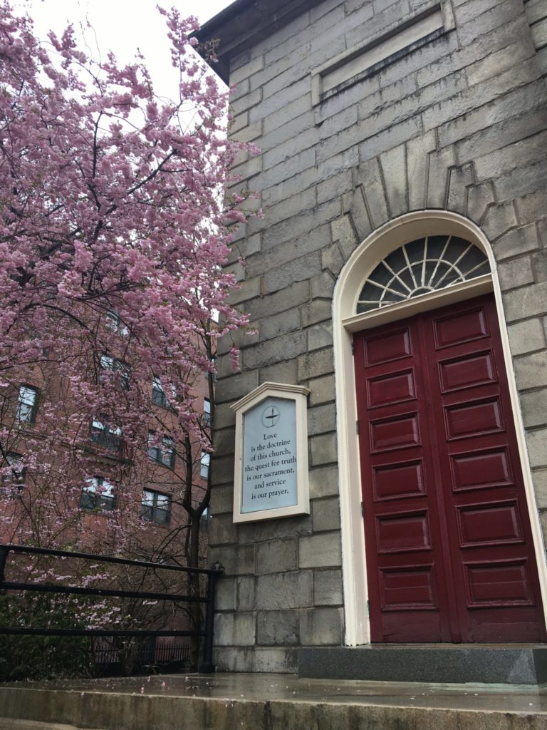 Church door with a flowering tree beside it in Portland ME