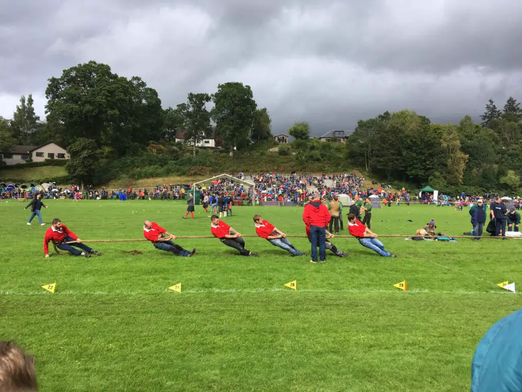 Men in red shirts compete in the tug-of-war at the Pitlochry Highland Games