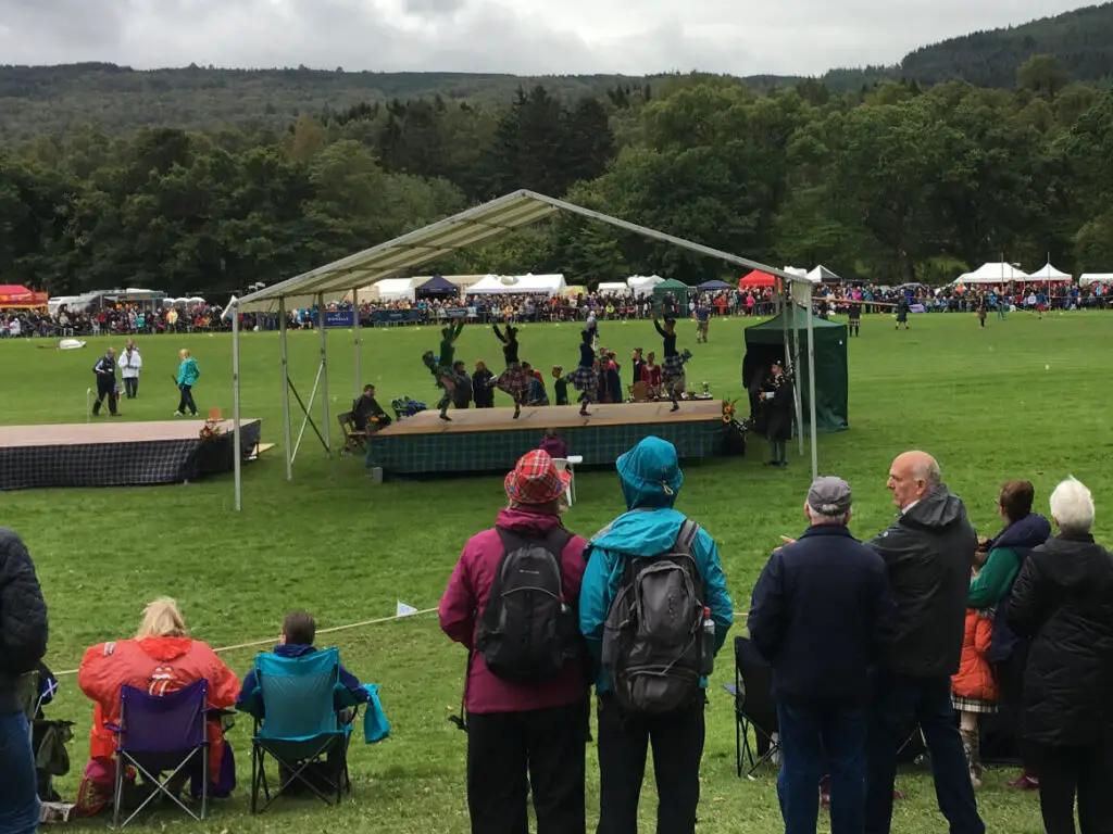 Highland dancers on a covered stage at the Pitlochry Highland Games