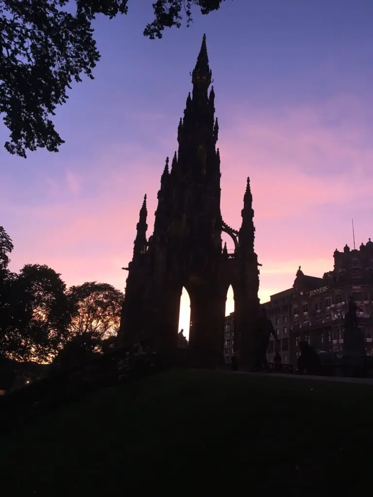 Scott Monument in Edinburgh with a cotton candy sunset sky backlighting its Gothic frame